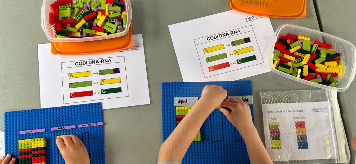 Piezas de lego del taller de mutaciones genéticas del VHIO con manos infantiles