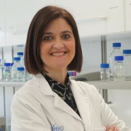 Dra. Elena Élez con bata VHIO con laboratorio de fondo